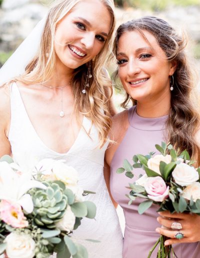 Bride wearing custom pearl wedding jewelry and bridesmaid in gold and pearl hoops